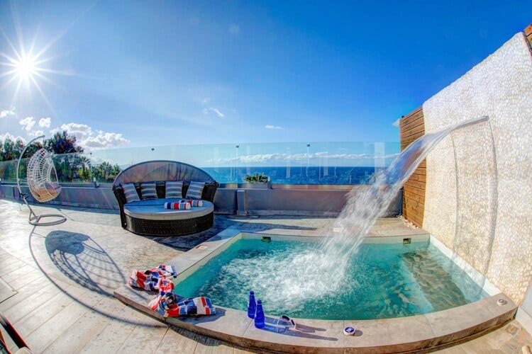 deck overlooking sea with pool and fountain