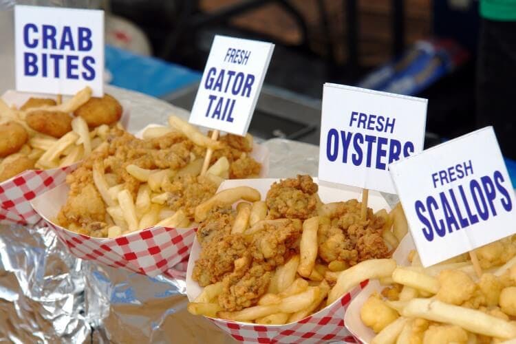 A selection of bite-sized fried Floridian seafood, including gator tail, crab, oysters, and scallops