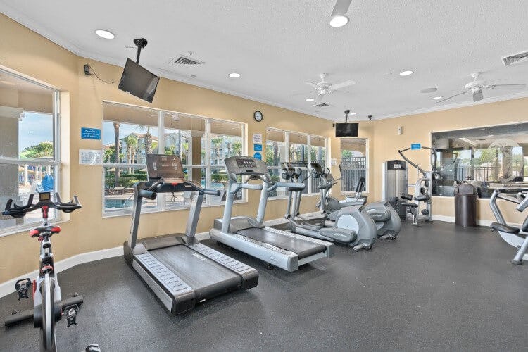 Windsor Hills Resort fitness center with treadmills and static cycles on a dark floor