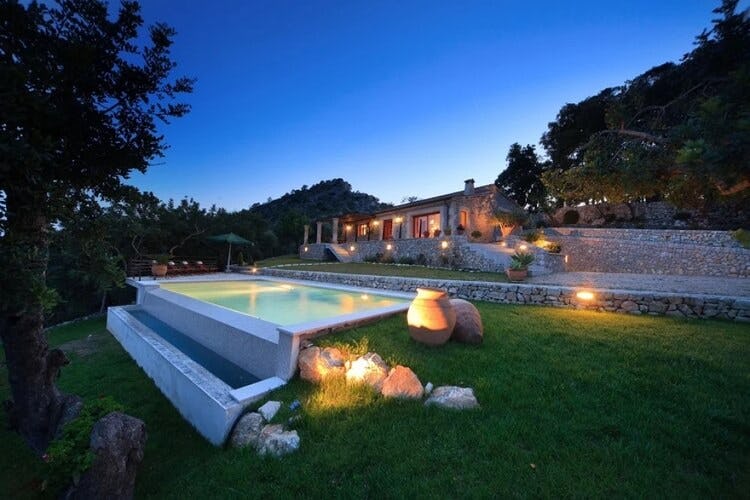 stone villa with infinity pool at dusk