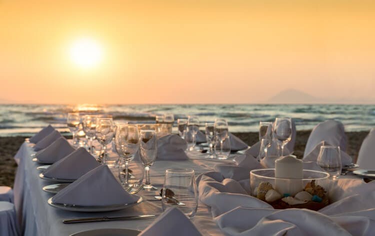 set dining table on beach at sunset