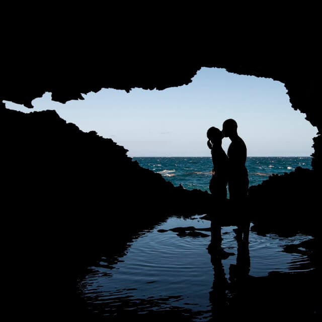 A couple kiss in silhouette in Animal Flower Cave, Barbados