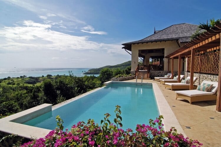 infinity pool with loungers overlooking ocean