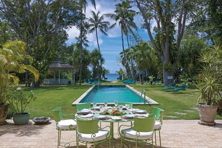 outdoor dining area with pool and greenery