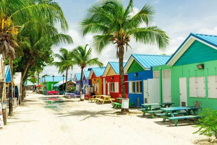 Colorful beach huts lining a street near the beach in Barbados