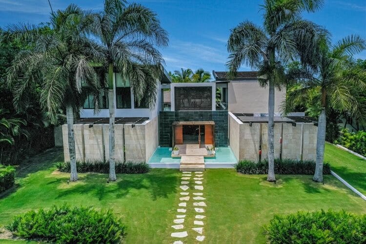 modern grey villa with lawn and palm trees
