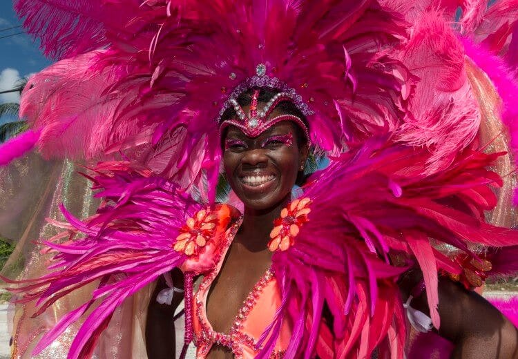 A lady dressed in a vibrant pink feathered costume for Crop Over Festival in Barbados