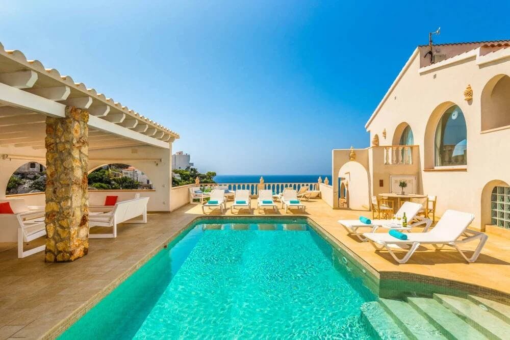 white villa with pool and view of ocean