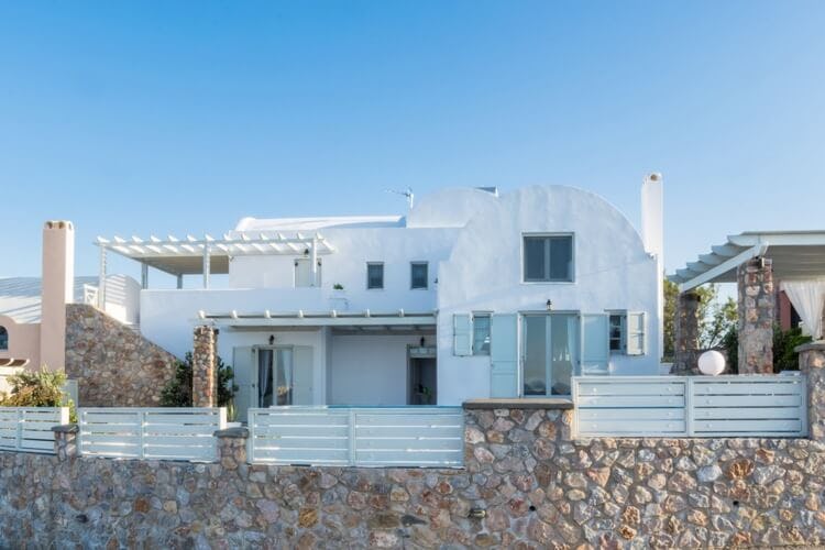 white villa with stone wall in front
