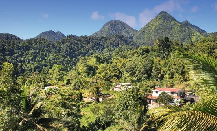 A view of the Dominican Republic landscape, mountains covered with tropical forests and buildings dotted amongst the trees