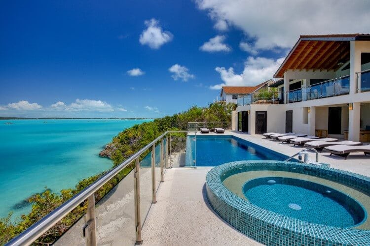 infinity pool and hot tub on deck overlooking ocean