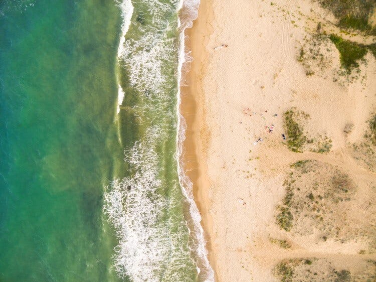 Ariel view of a white sand beach and waves