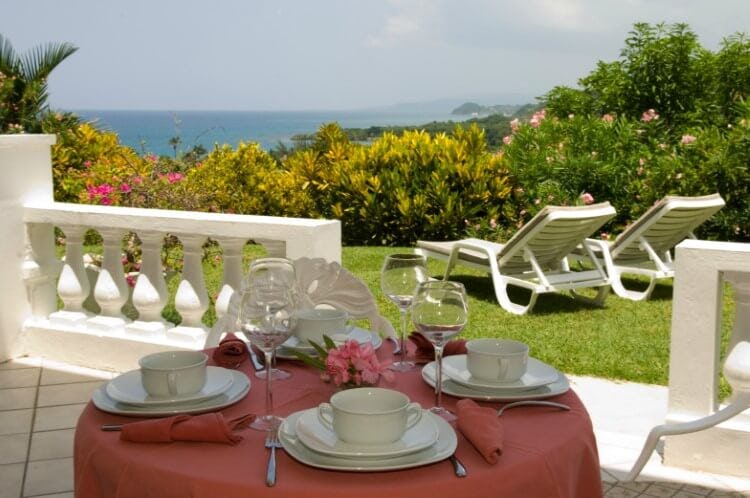 Mirador at the Tyrall Club villa outside garden area with tiled patio, table and two ocean-facing sun loungers