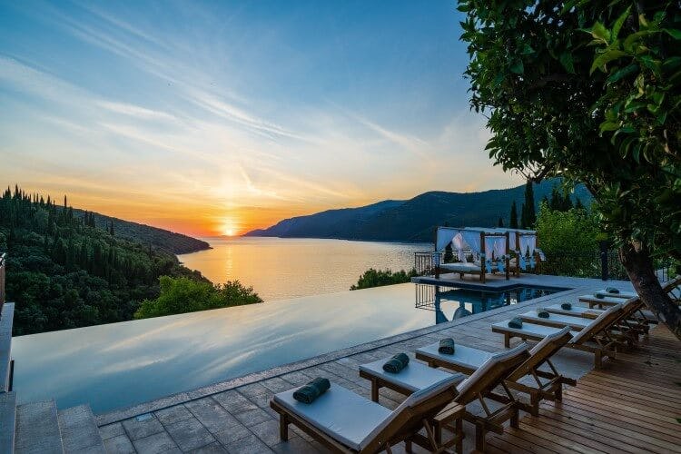 infinity pool with sunset over water