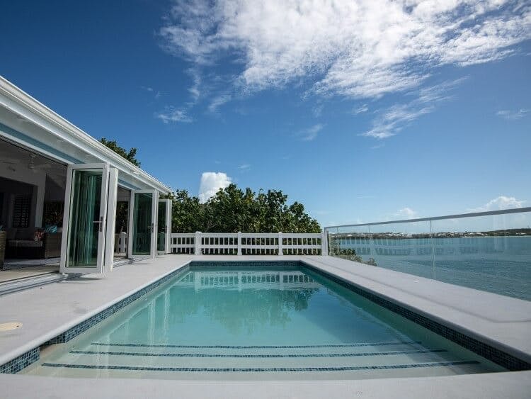 Moonshadow Villa rental private pool next to the home with a glass balcony overlooking the Caribbean Sea