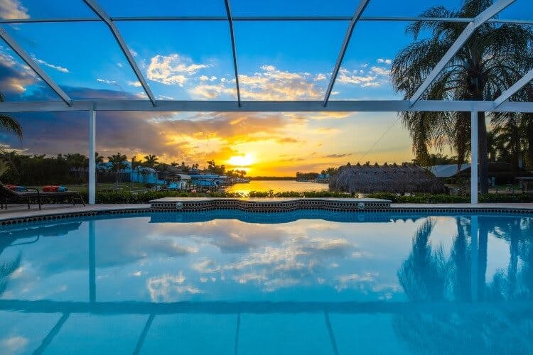 view of pool overlooking water at sunset