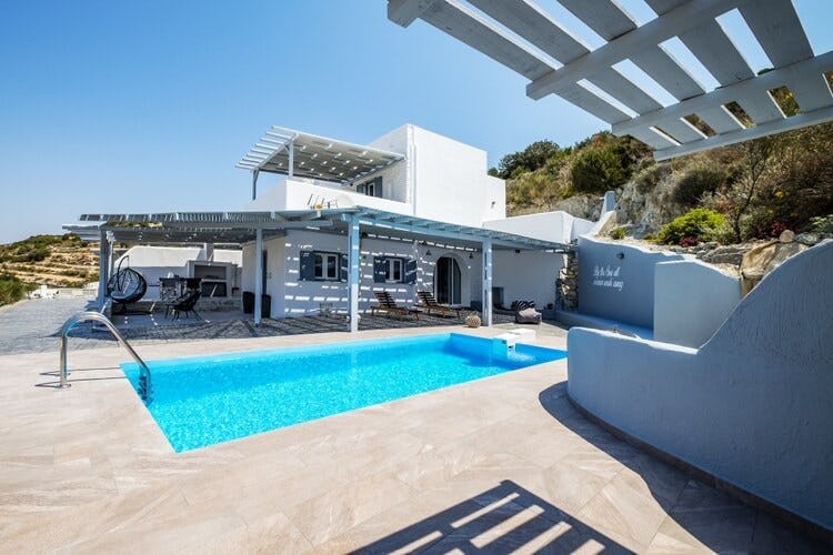 white villa with pool and shaded area