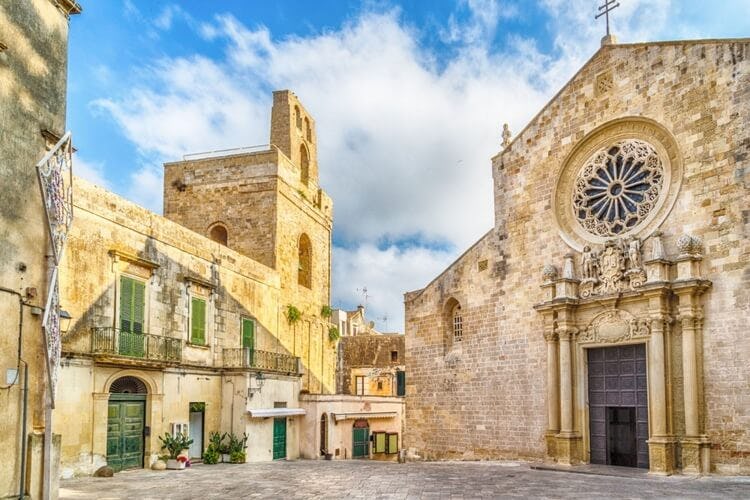 street of puglia with building on left and church on right