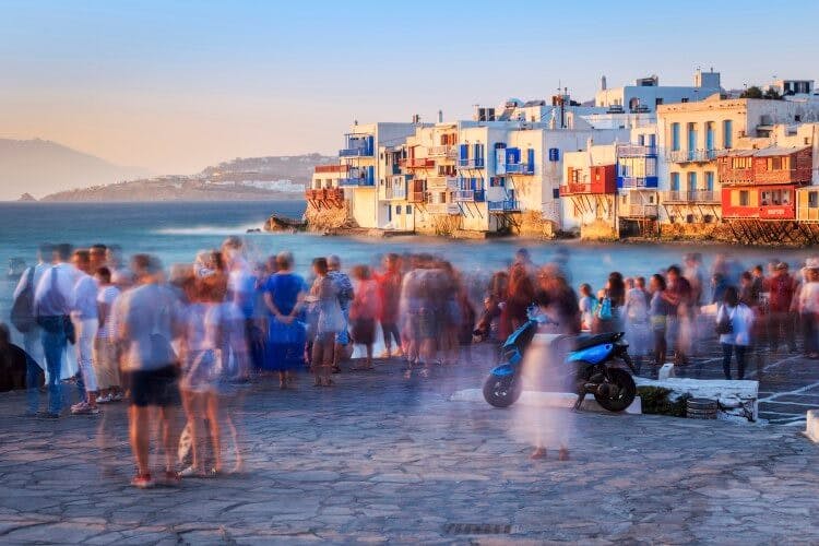 A long exposure shot of people gathering to watchthe sunset in Mykonos