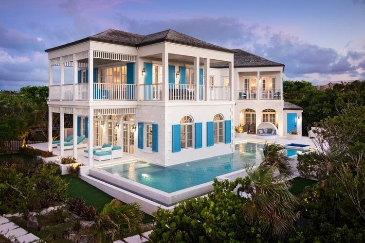 large white villa with pool at dusk