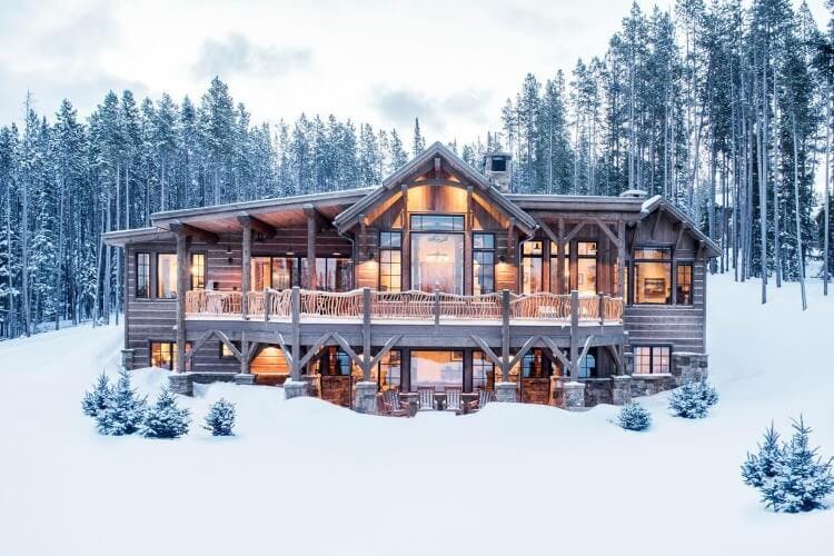 large lit up cabin in the snow