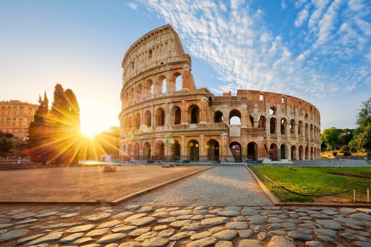 The Colosseum of Rome without people as the sun rises on the horizon