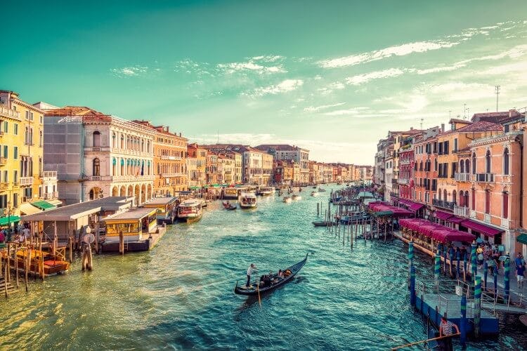 The GRand Canal of Venice - a long waterway with gondolas and boats and old buildings lining the waterside