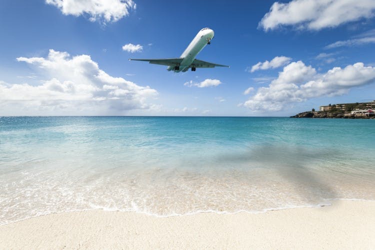 plane flying low over beach