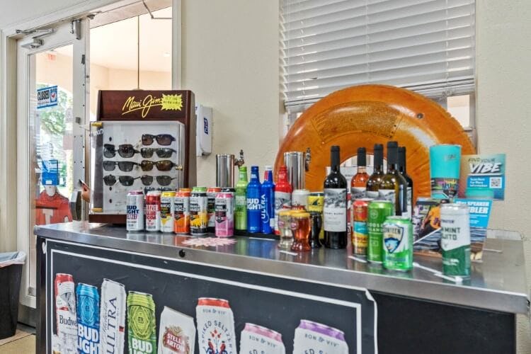 Windsor Hills Resort shop display, with a sunglass rack, bottles and cans of drink, sun screen bottles and an inflatable pool donut