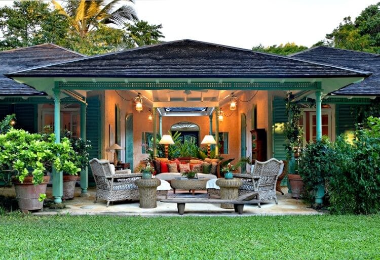 green villa with seating area and lawn
