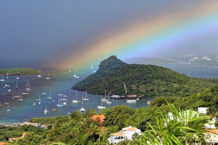 Simpson Bay landscape with harbor, forested headland and rainbow