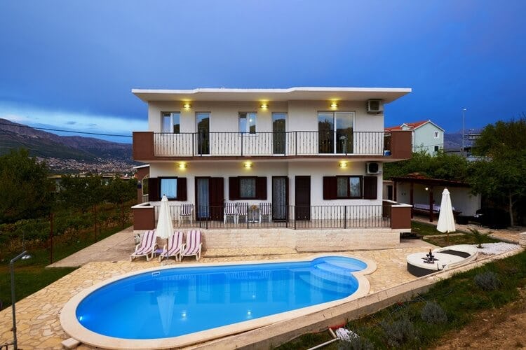 white villa with pool and town in background