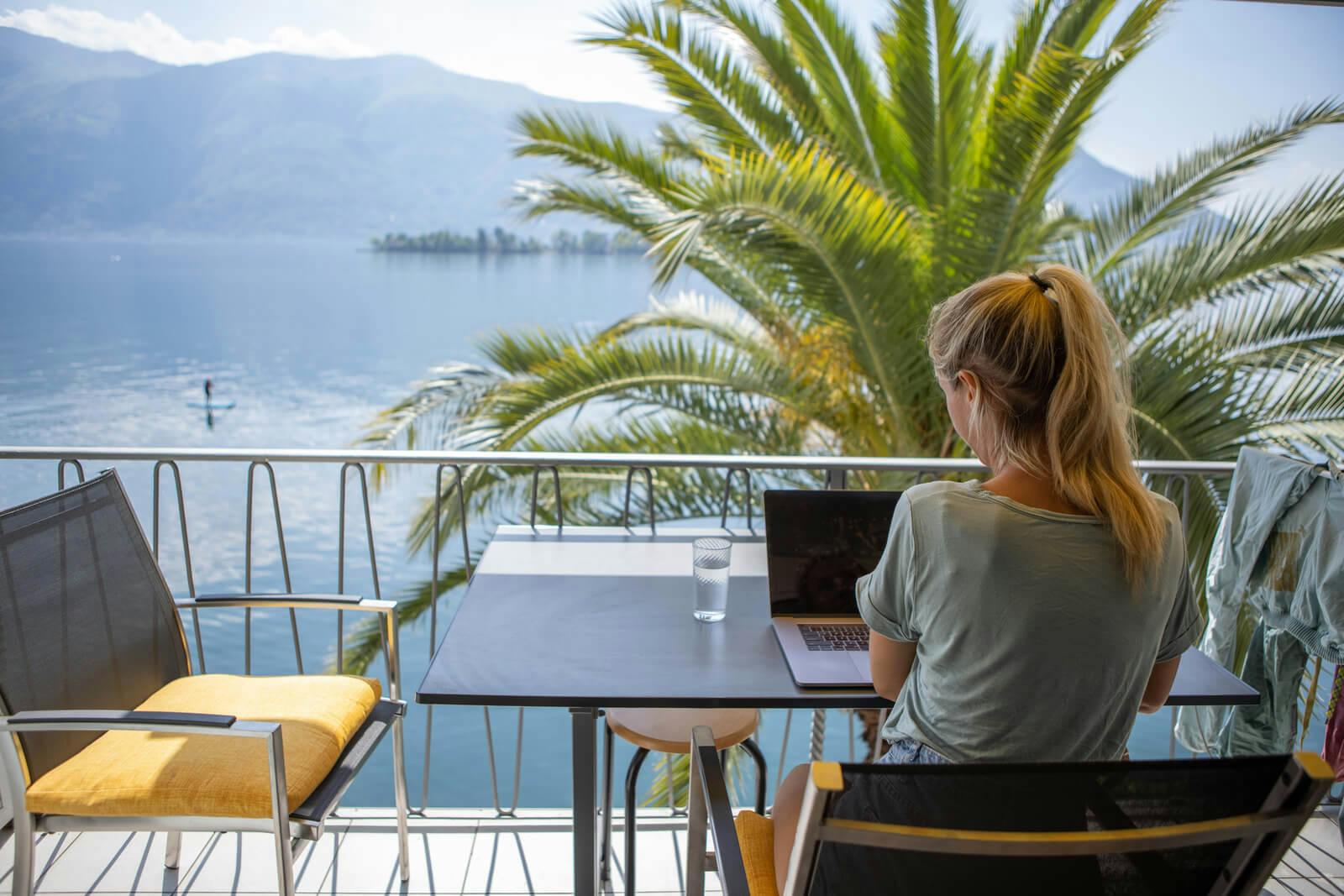 woman working on laptop overlooking ocean
