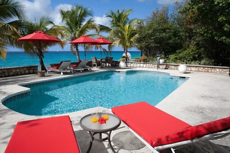 red lounger and pool overlooking ocean