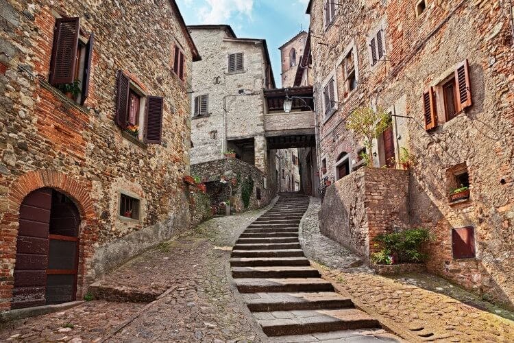 A narrow cobbled street in Arezzo, flanked by tall stone houses