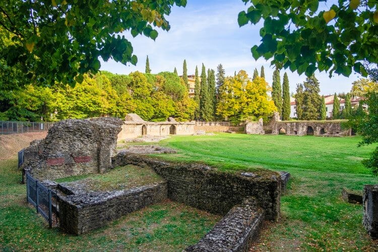 Ruins of a Roman Ampitheater in a green field in Arezzo