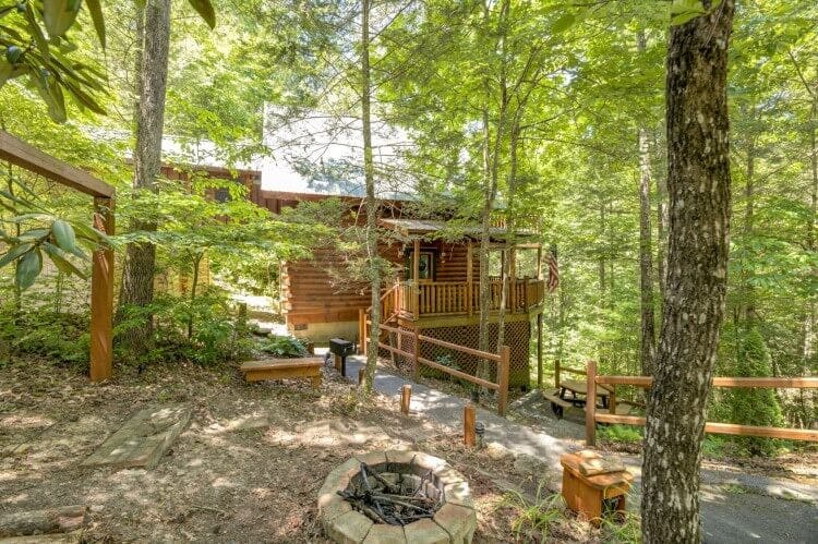 log cabin and fire pit in the woods