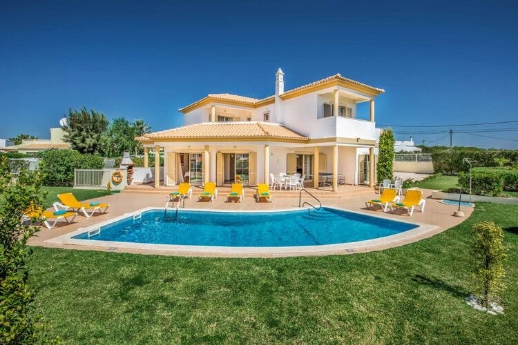 white villa with yellow loungers, pool and lawn