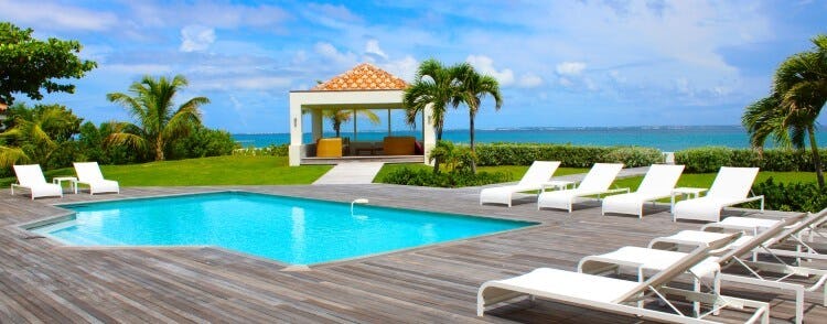 pool on deck with loungers and ocean in background