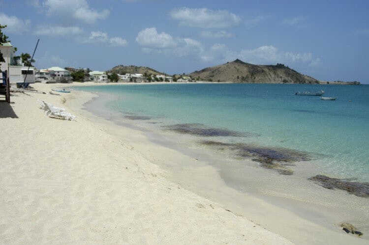 Grand Case, a beach in Saint Martin with white sand, clear water and rocky headland