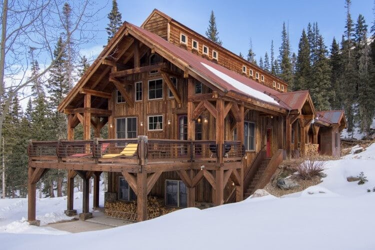 large cabin with balcony in the snow