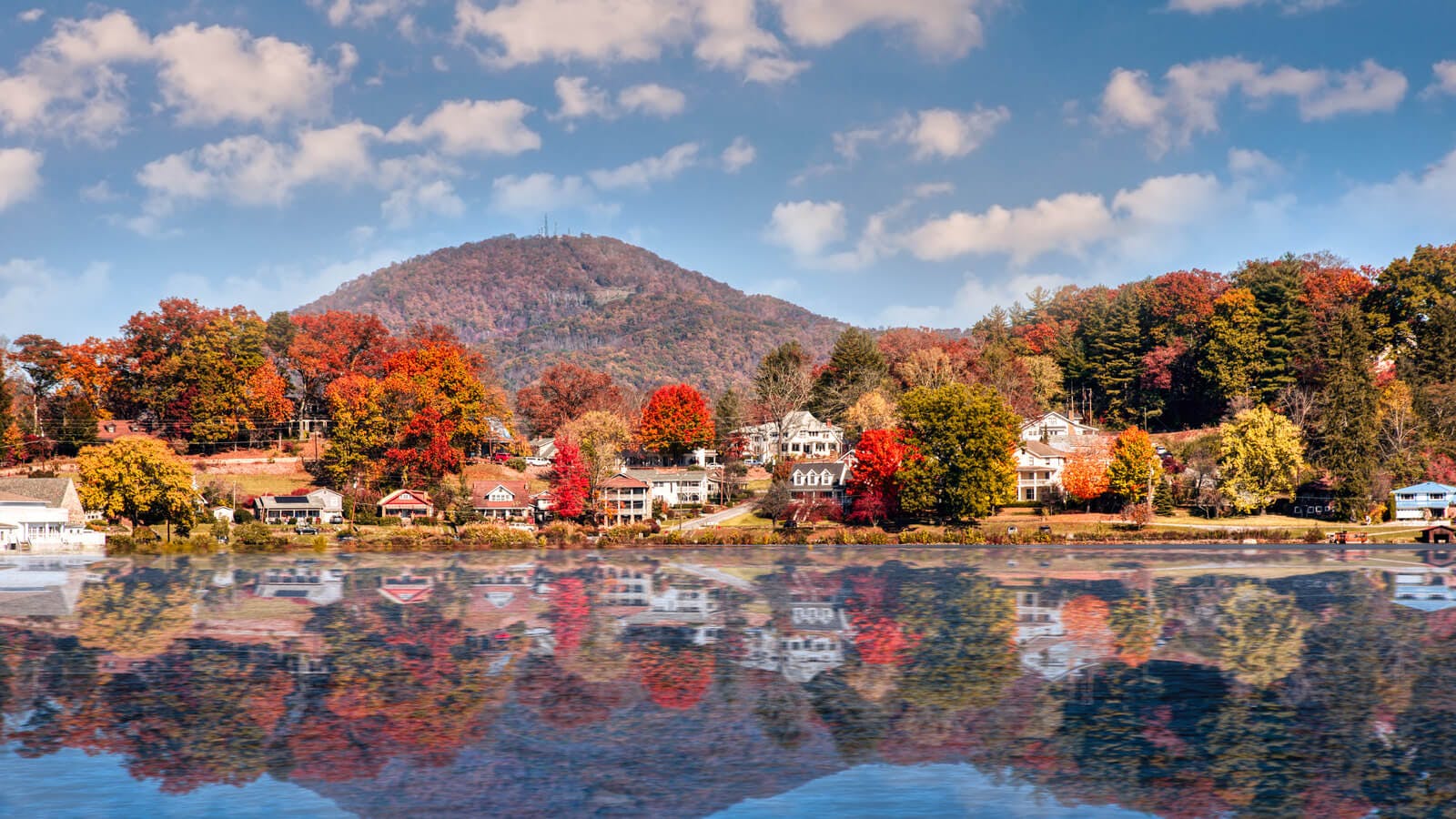 Lake Junaluska in Asheville, North Carolina, with fall-colored trees and a mountain backdrop