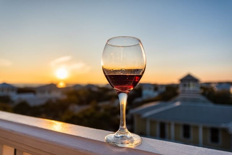 A glass of read wine on a railing in Seaside, Florida