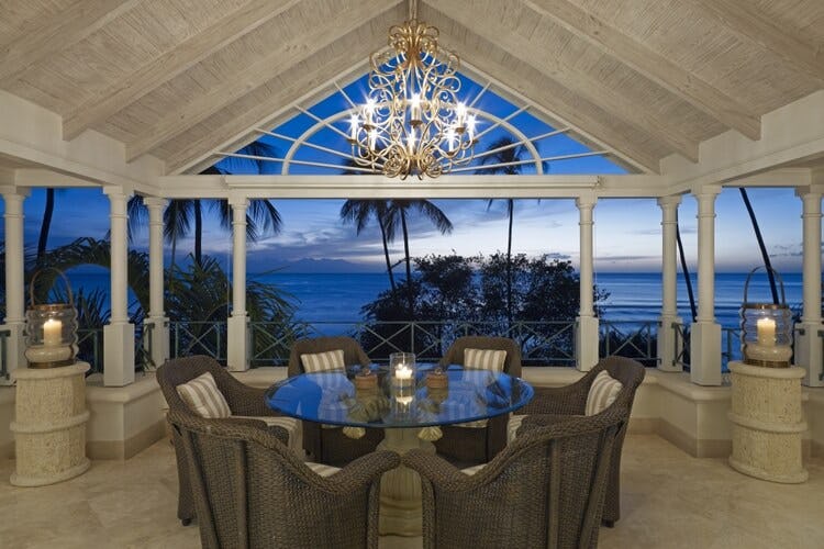 covered dining area overlooking ocean at dusk