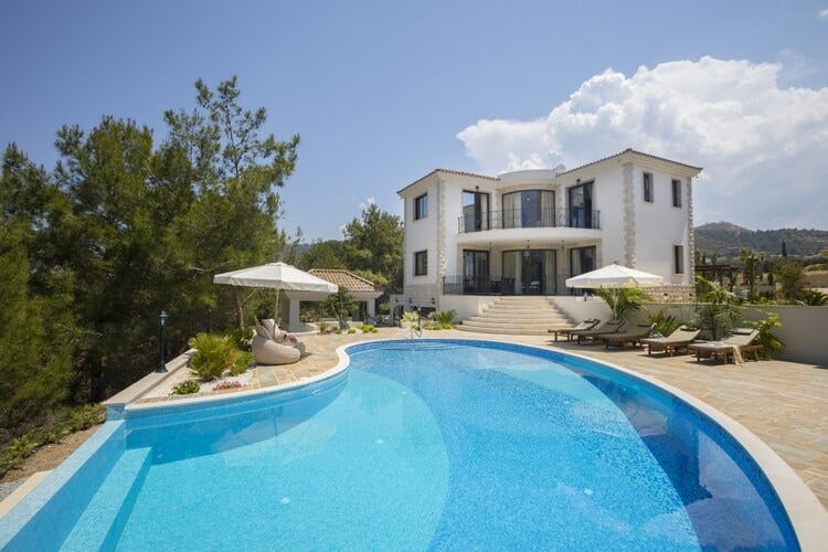 grand white villa with pool and loungers