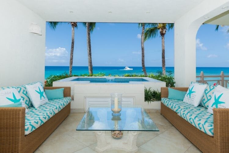 covered seating area with hot tub and ocean