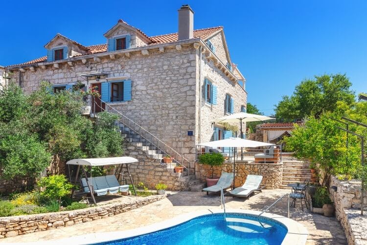 stone villa with blue shutters and pool