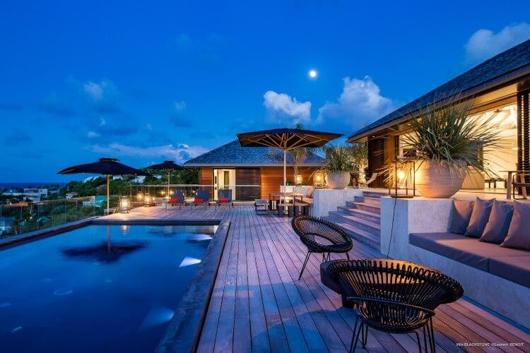 deck of vacation home with infinity pool at dusk