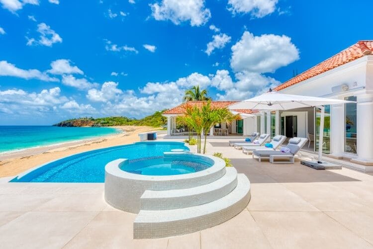 white villa on beach with pool and hot tub