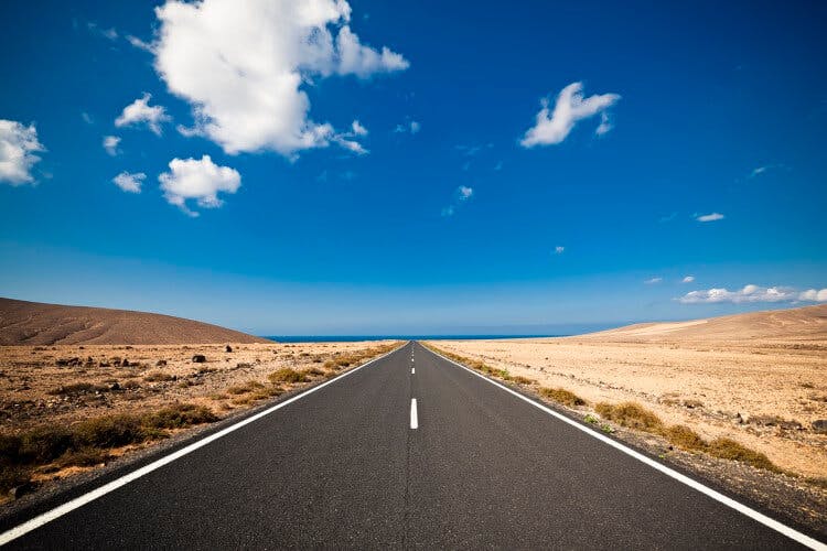 A long, straight road towards the sea on Fuerteventura